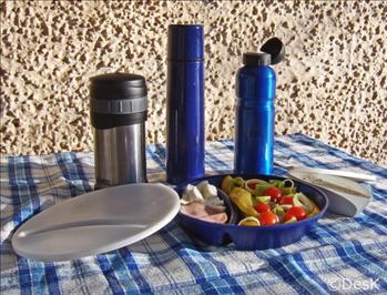 Bild på med olika bra matlådekärl. Tredelad tallrik med sallad, dressing och fårost, matthermos, drickaflaska och kaffethermos.